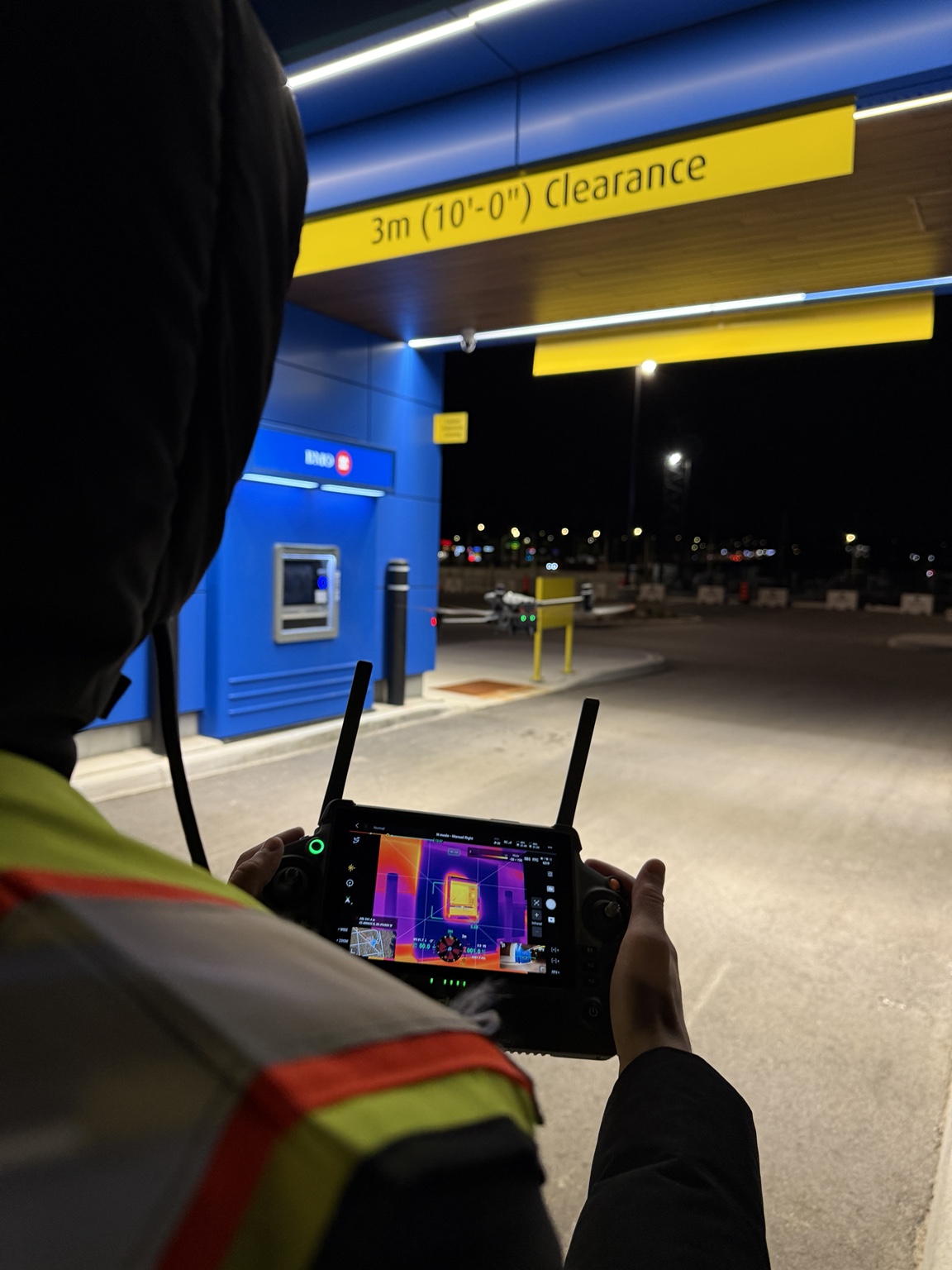 Drone operator using thermal controller during night inspection